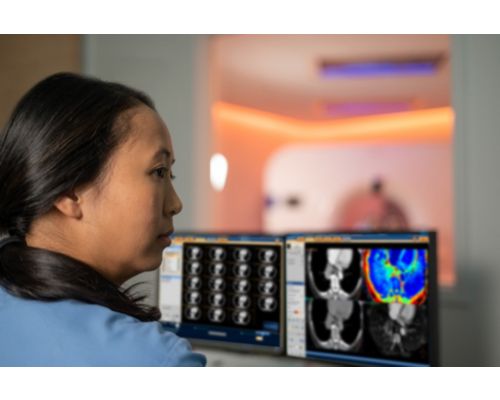 Radiologist and tech looking at screen in control room